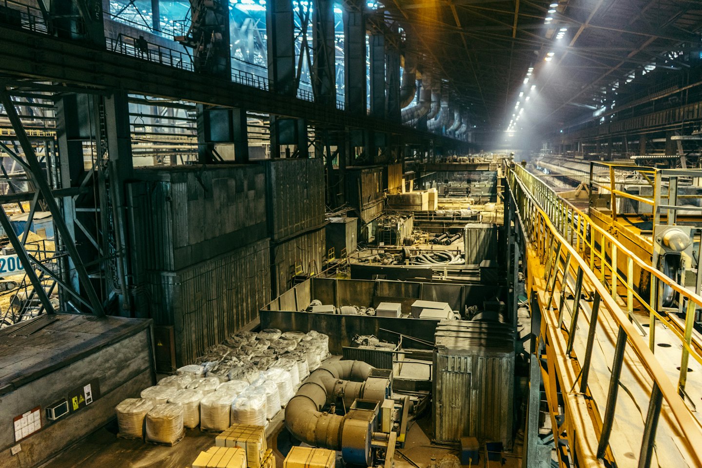 Interior of a busy industrial manufacturing plant with machinery and pipes.